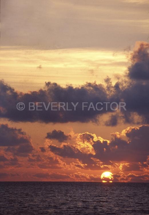 Islands;sunsets;sky;clouds;colorful;blue water;sun;yellow;red;pink;sillouettes;blue;maldive island